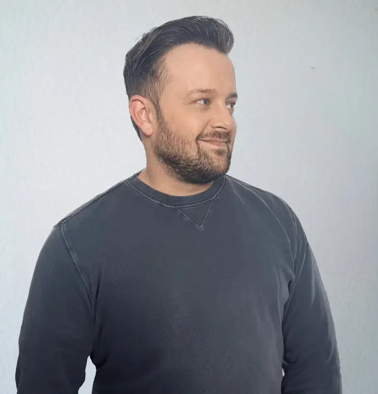David Keiser, Webdesigner und SEO-Experte, im dunklen Pullover vor hellem Hintergrund