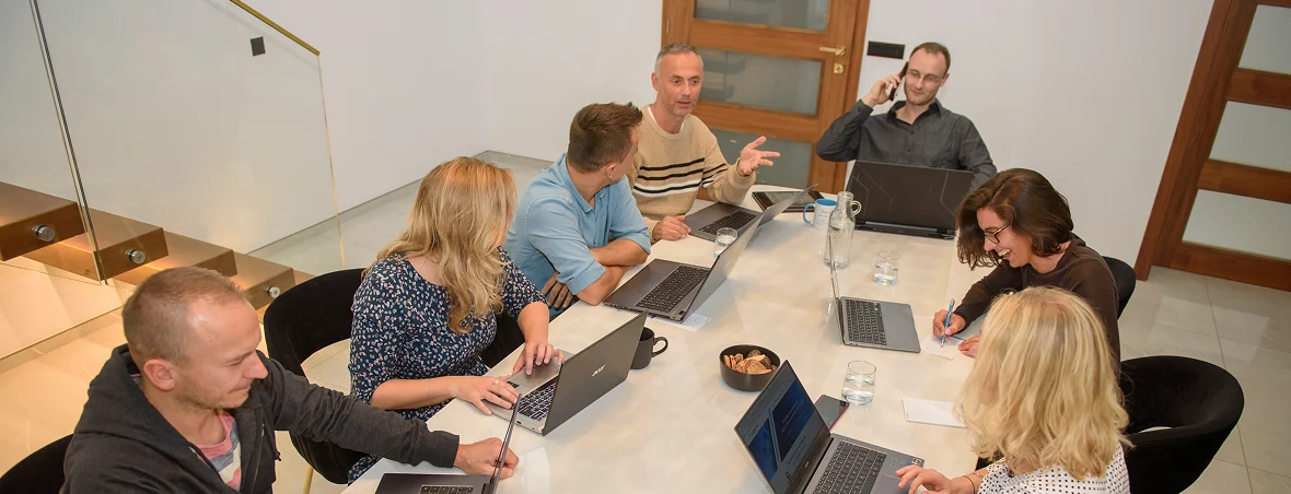 Das gesamte Team der SEO Revolution sitzt zusammen am Konferenztisch und tauscht sich über aktuelle Projekte aus.