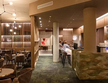 Elegante Hotelbar und Lounge im H24 Hotels mit warmer Beleuchtung und modernem Interieur.