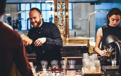 Barista serviert Kaffee im Café des H24 Hotels in entspannter Atmosphäre.