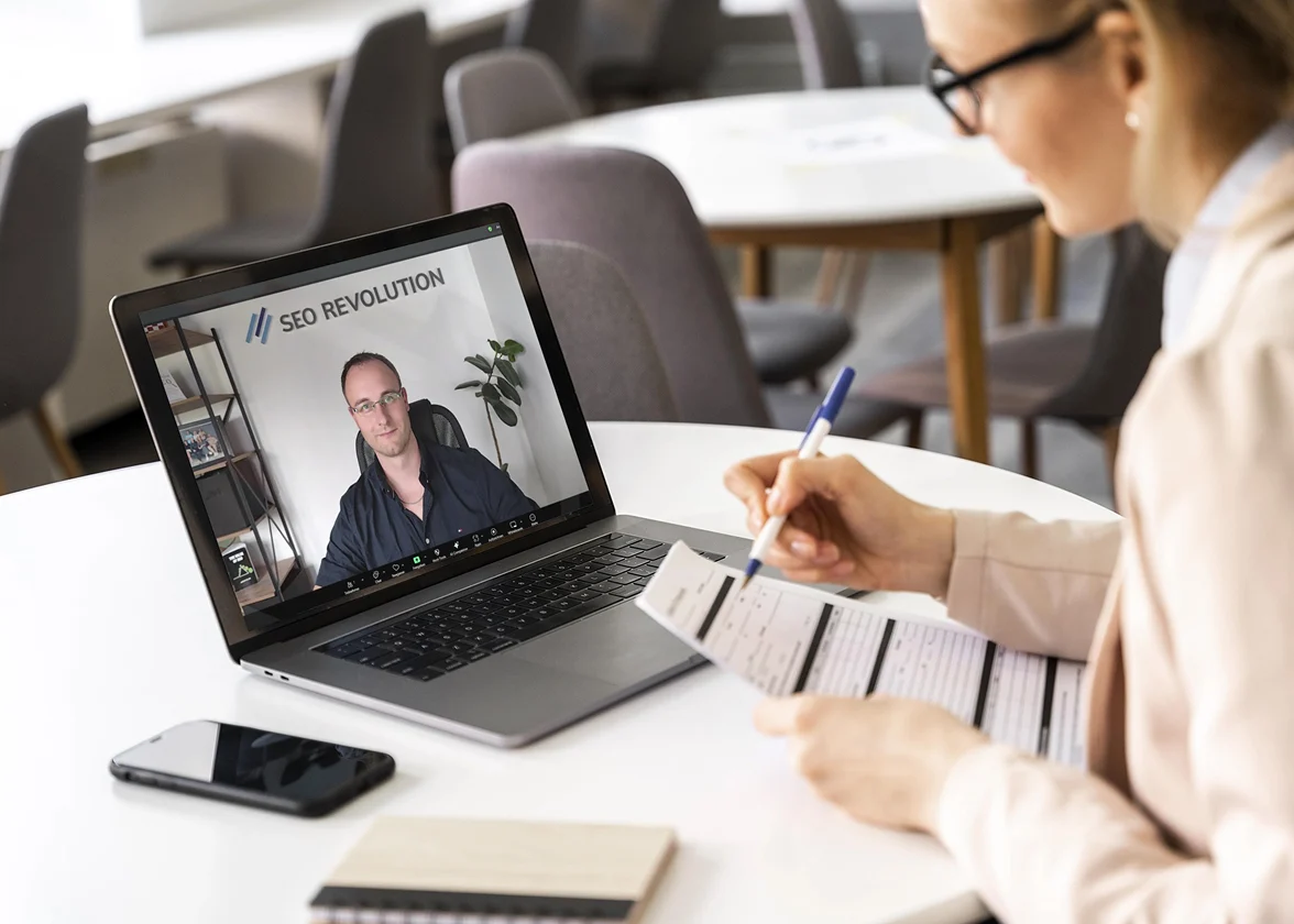 Frau im Online-Meeting mit SEO Revolution – Beratungsgespräch über Laptop mit Notizen und Unterlagen
